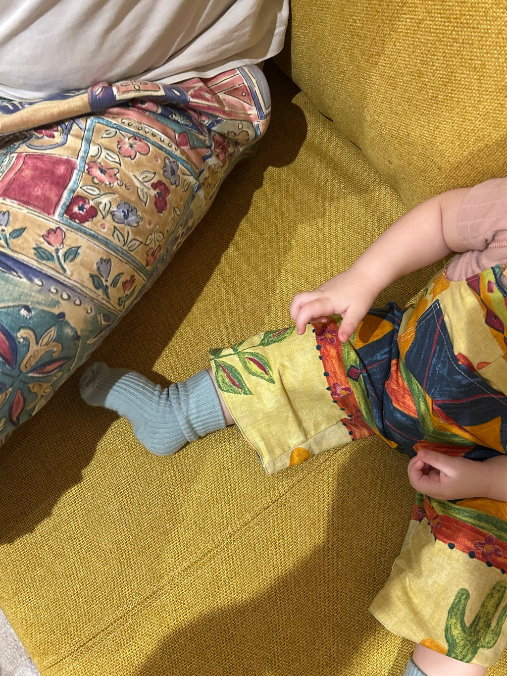 Child playing with a colorful bag on a patterned couch