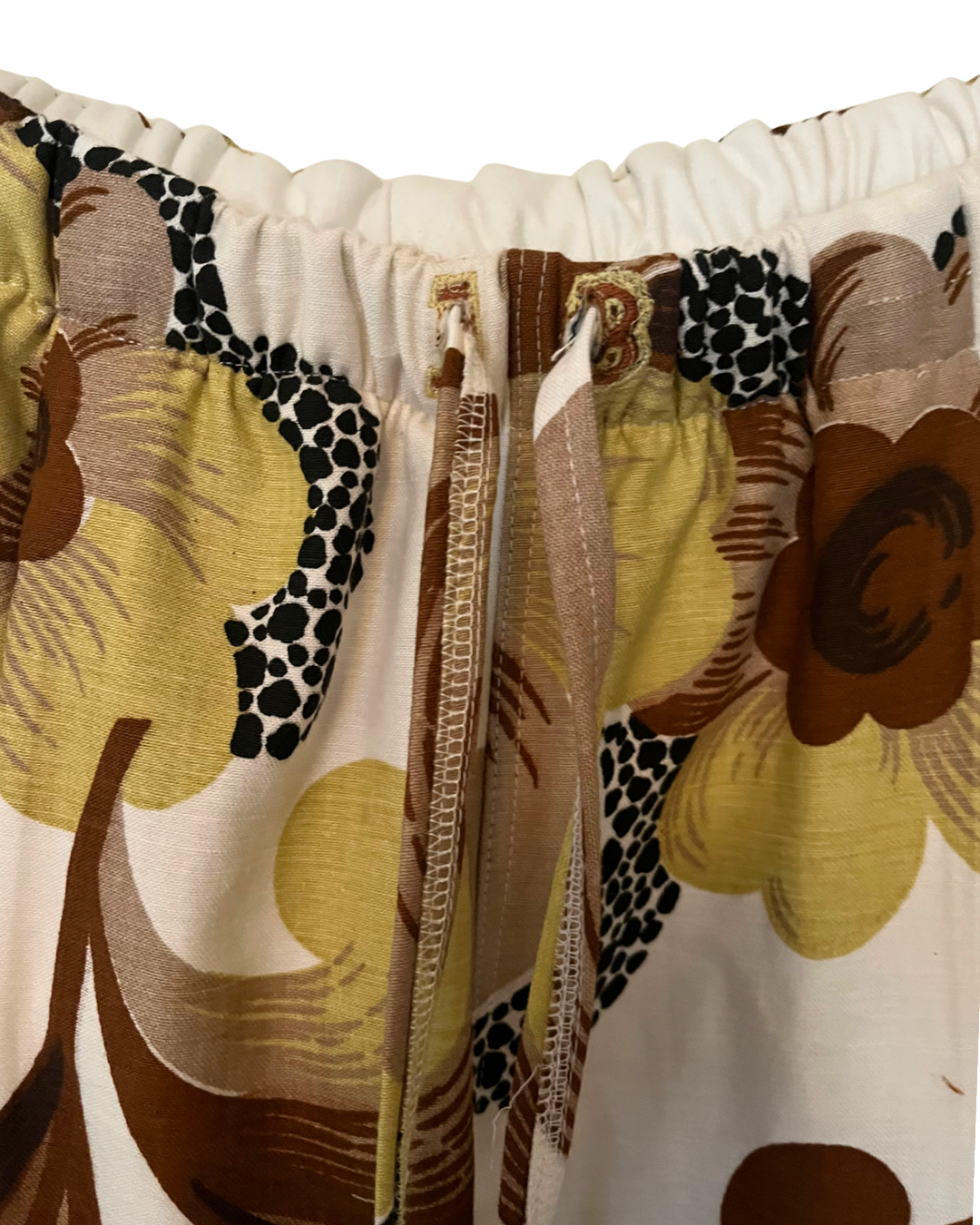 Close-up of a floral patterned fabric with brown, yellow, and black colors.