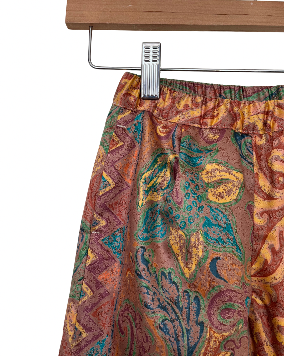 Patterned trouser hanging on a rack with a white background