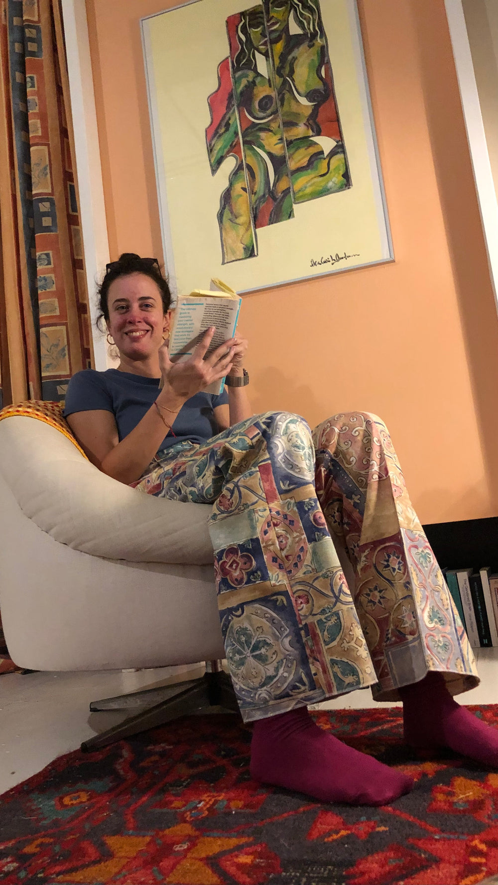 Woman reading a book in a cozy room with colorful decor