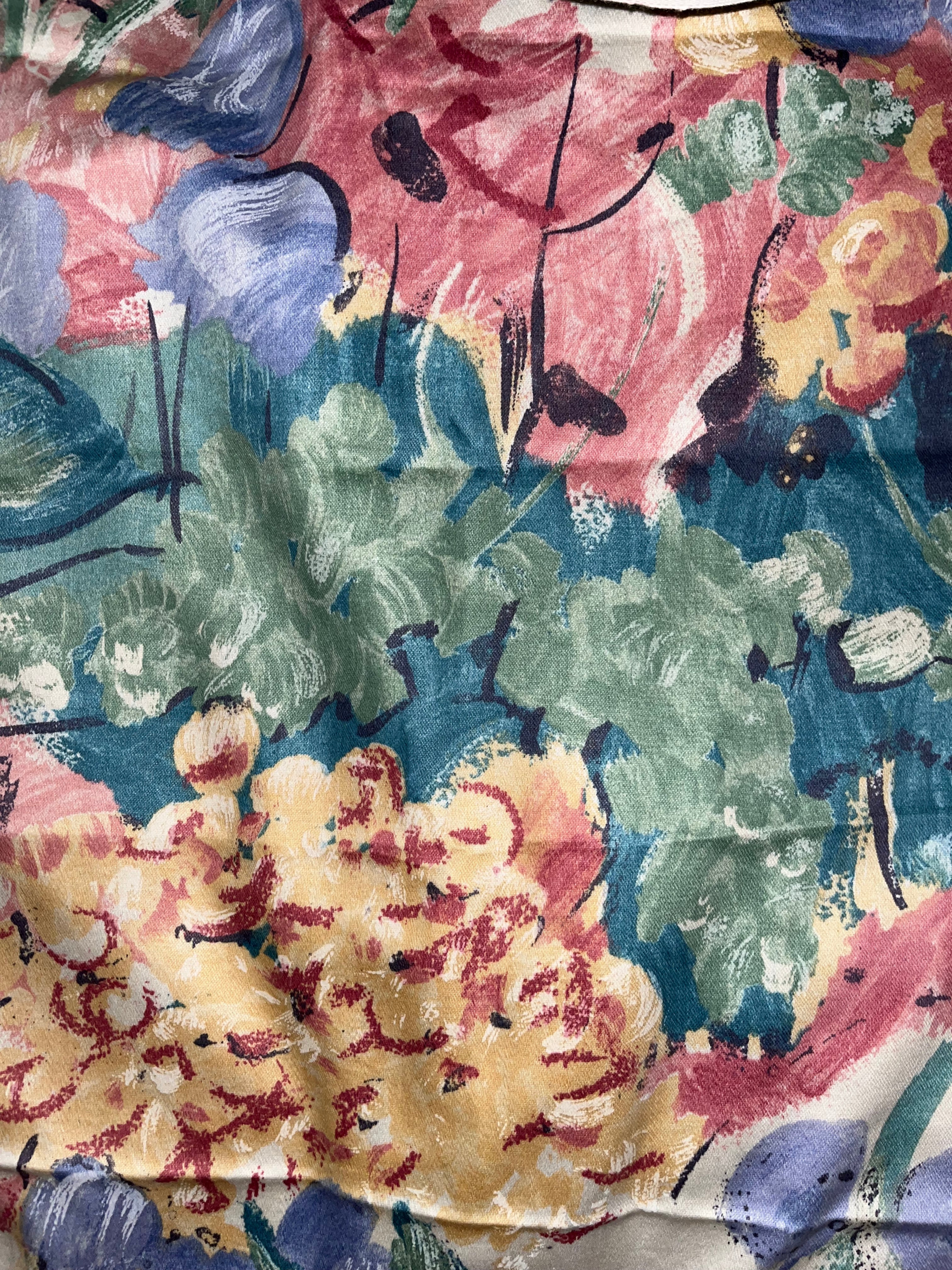 Close-up of a colorful floral fabric pattern with pink, green, and blue colors.
