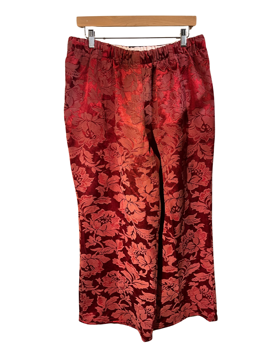 Red floral patterned skirt on a hanger against a white background