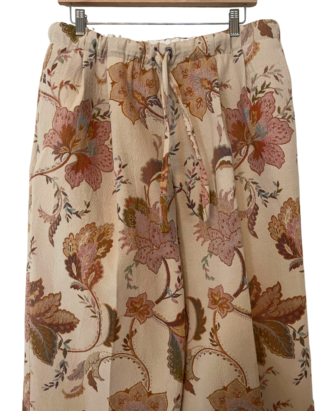 Floral patterned skirt on a hanger against a white background