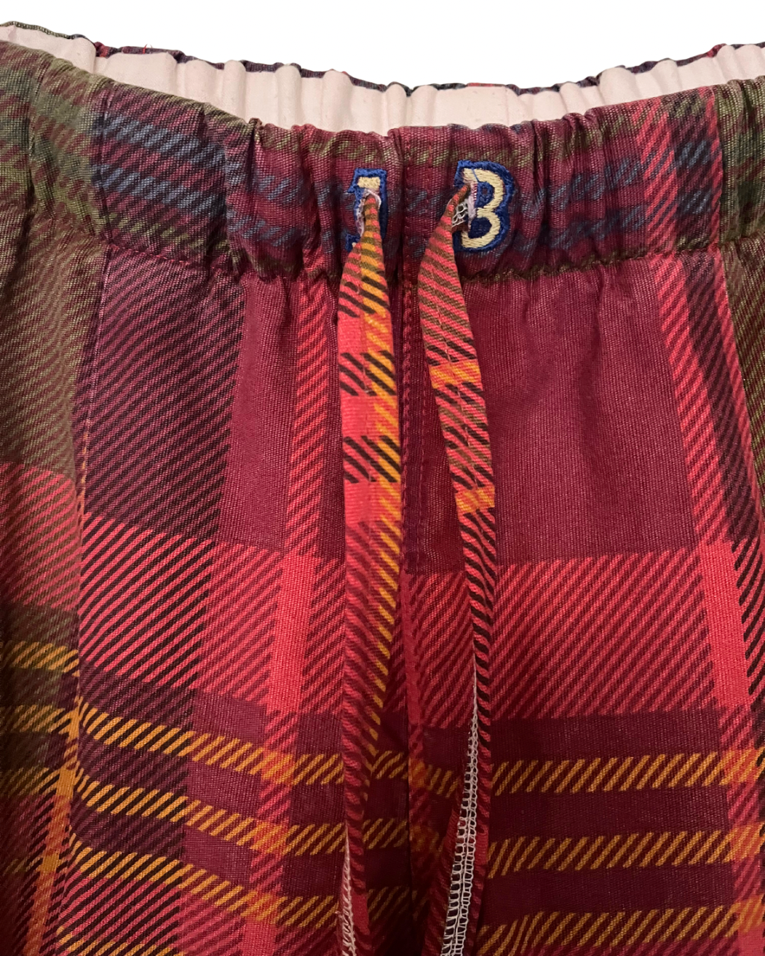 Plaid fabric with a visible brand logo in the center