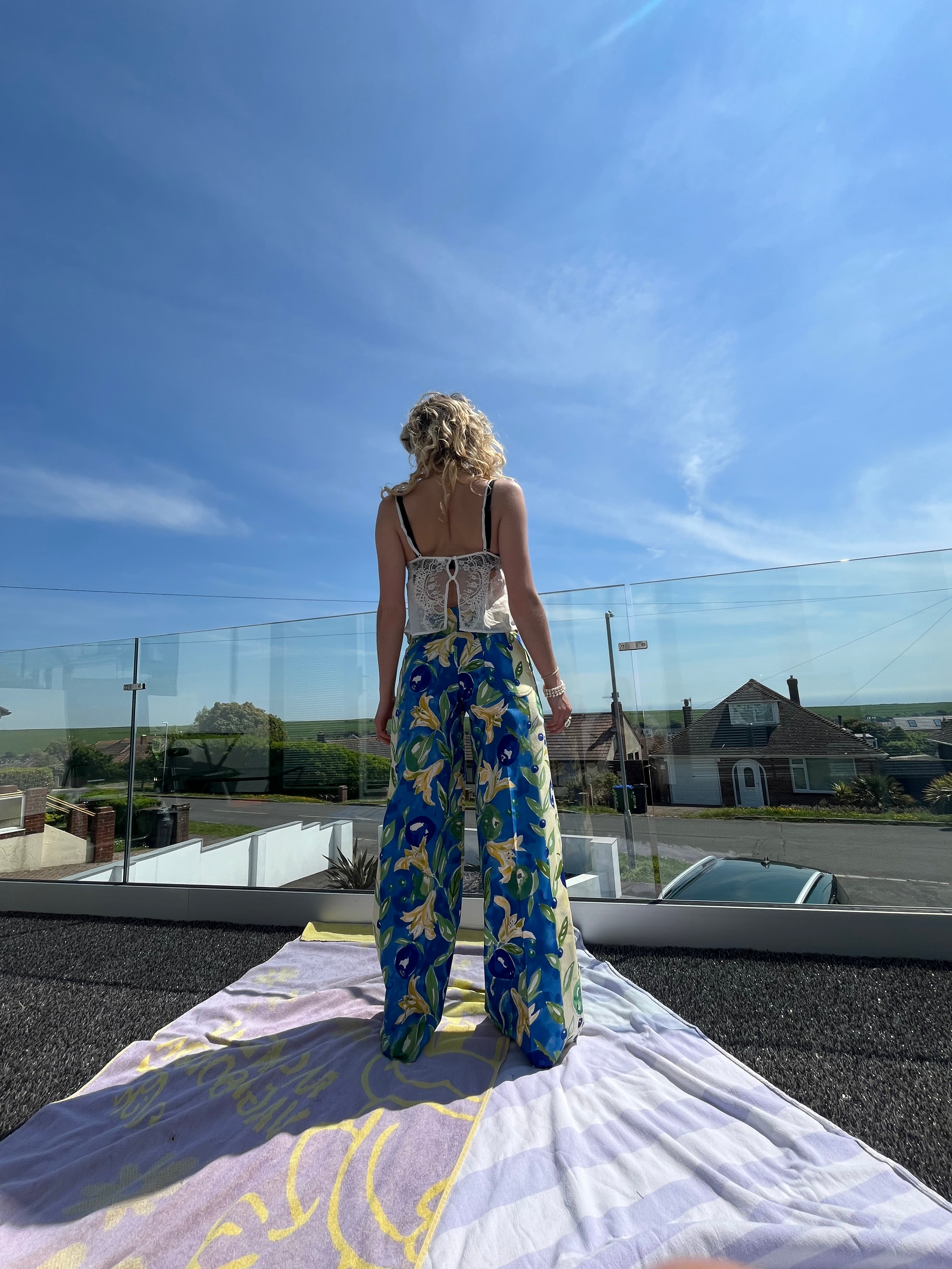 Person in a blue and yellow patterned trouser outdoors with a clear sky.