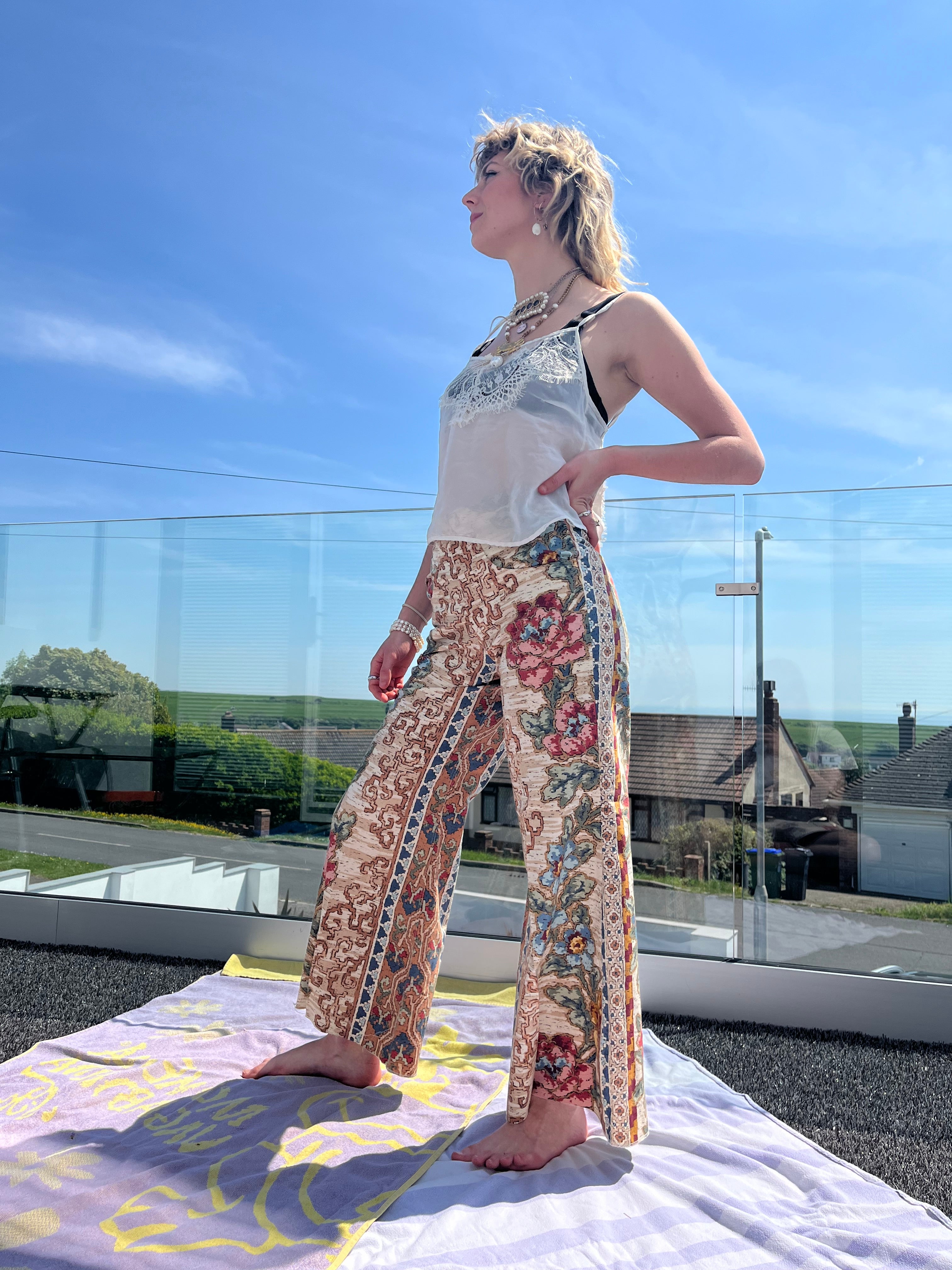 Person wearing a floral trouser with a blurred outdoor background