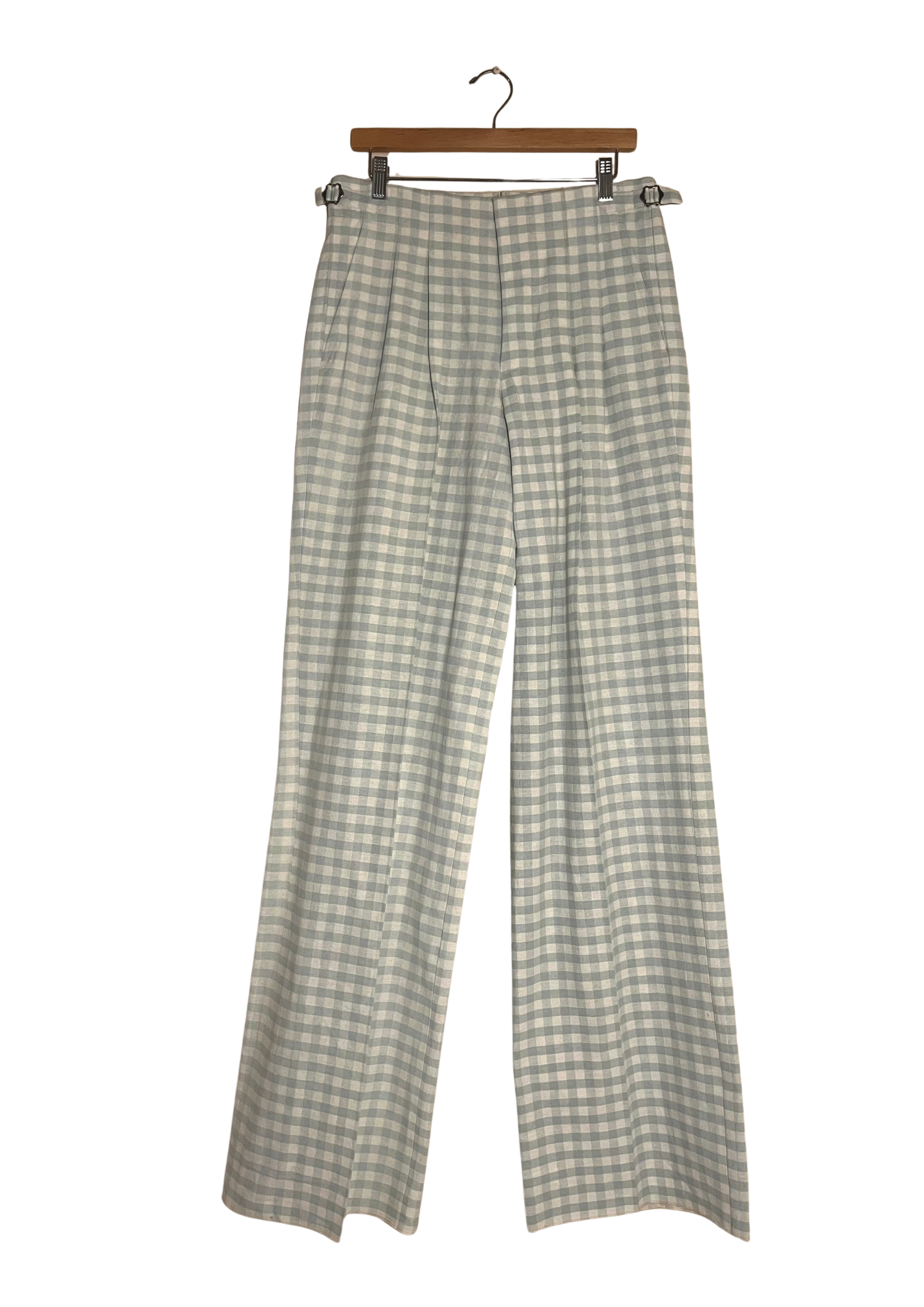 Checkered pants hanging on a wooden hanger against a white background