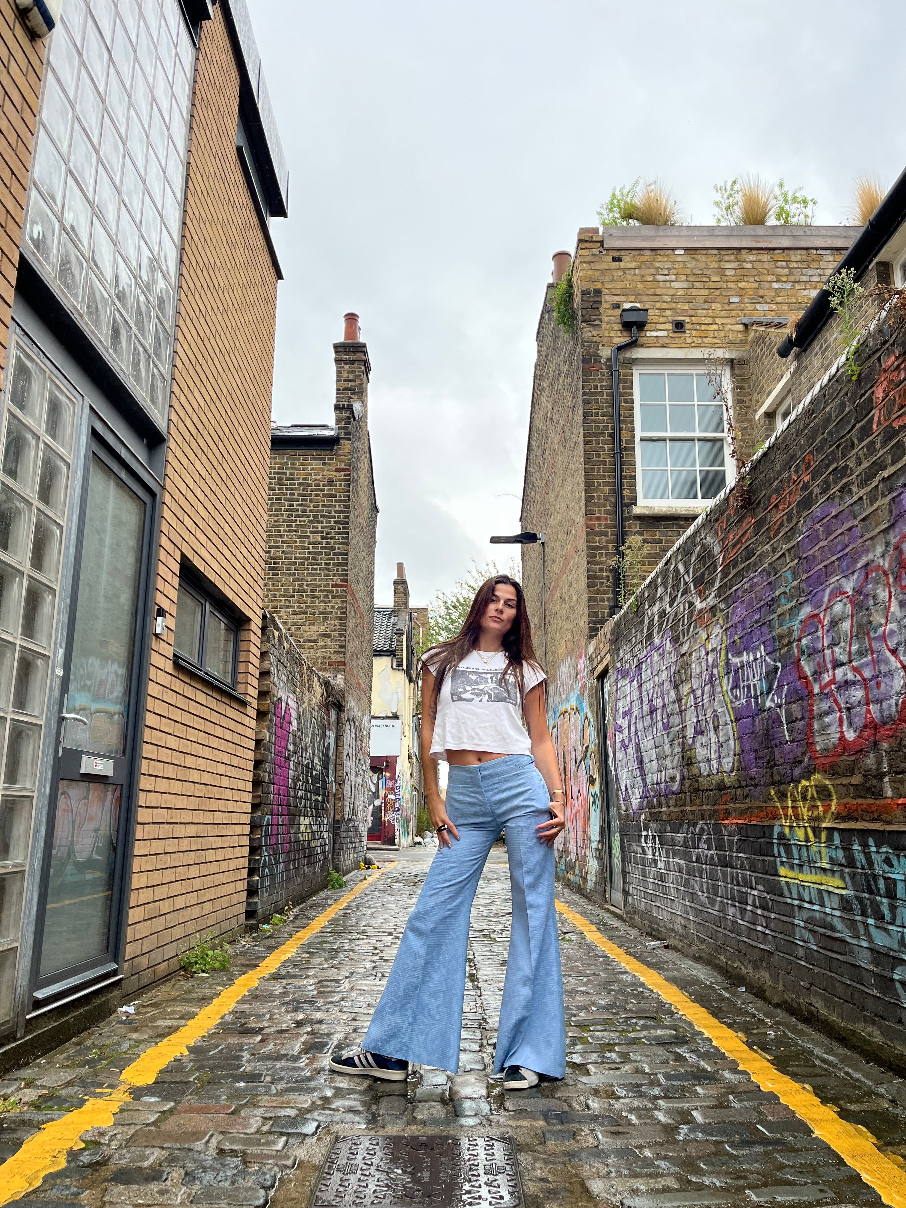 Woman standing in a narrow alley with buildings on either side