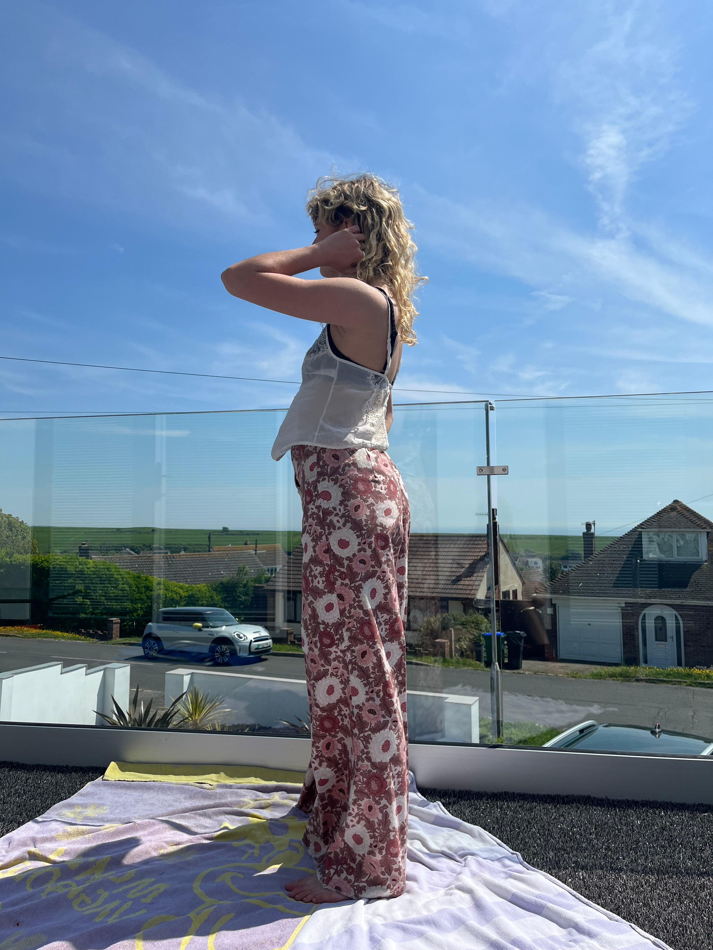 Person standing by a window with a clear blue sky reflection
