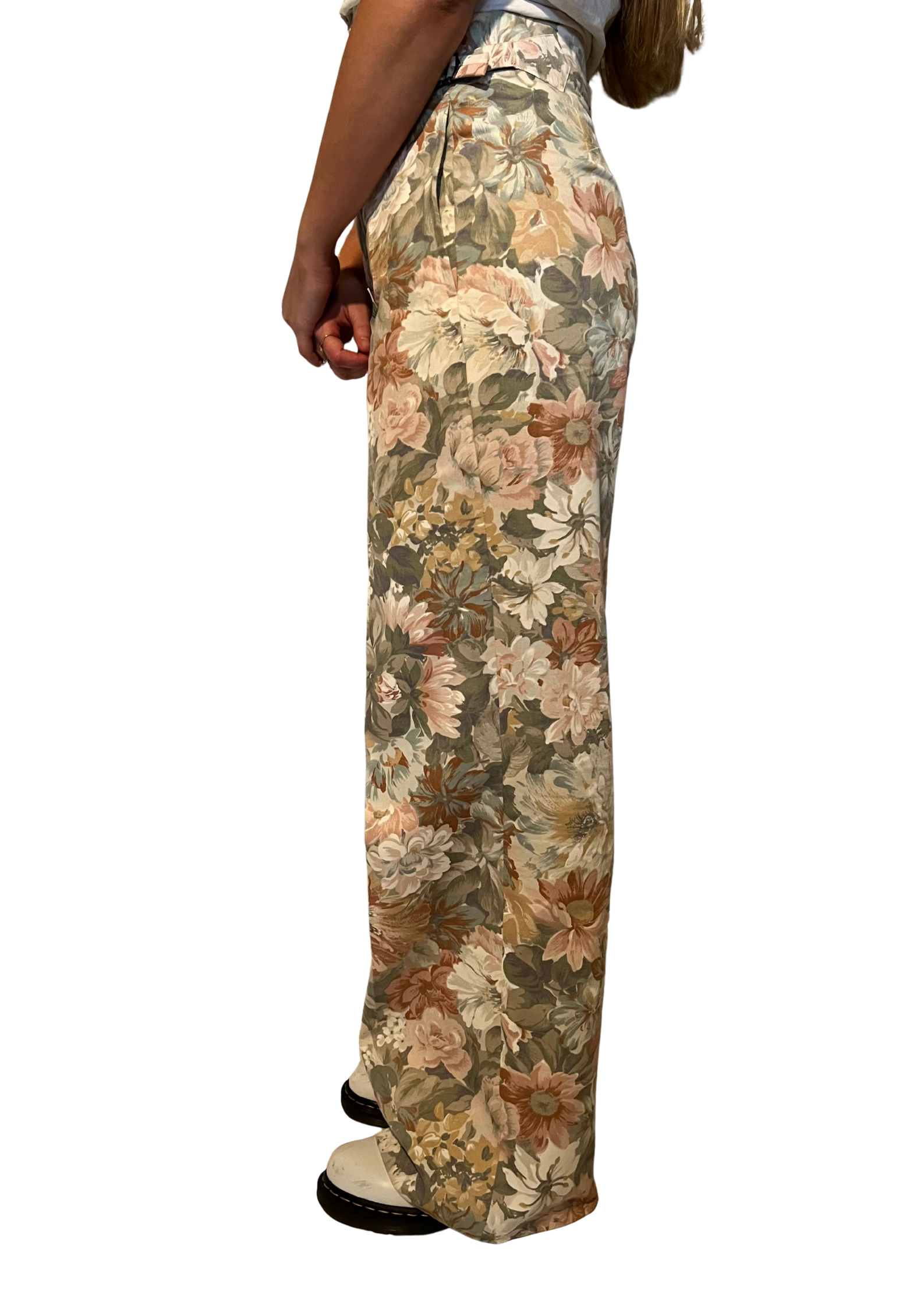 Floral patterned pants worn by a person on a white background