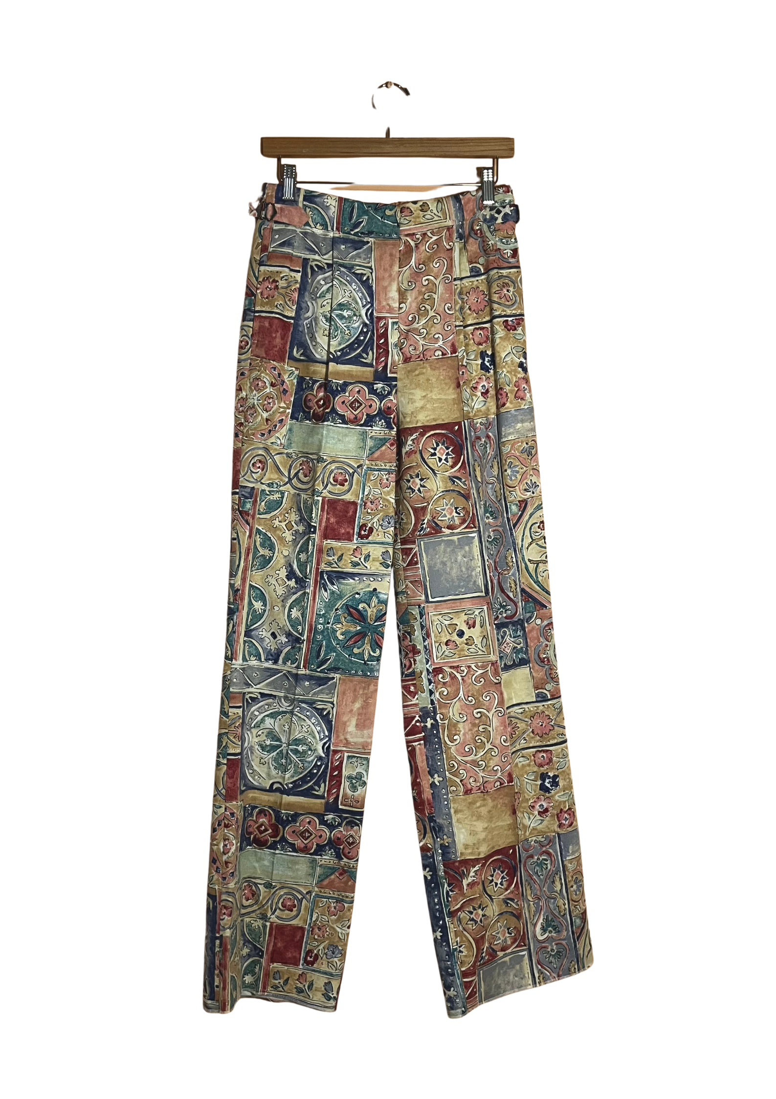 Colorful patterned pants on a hanger against a white background