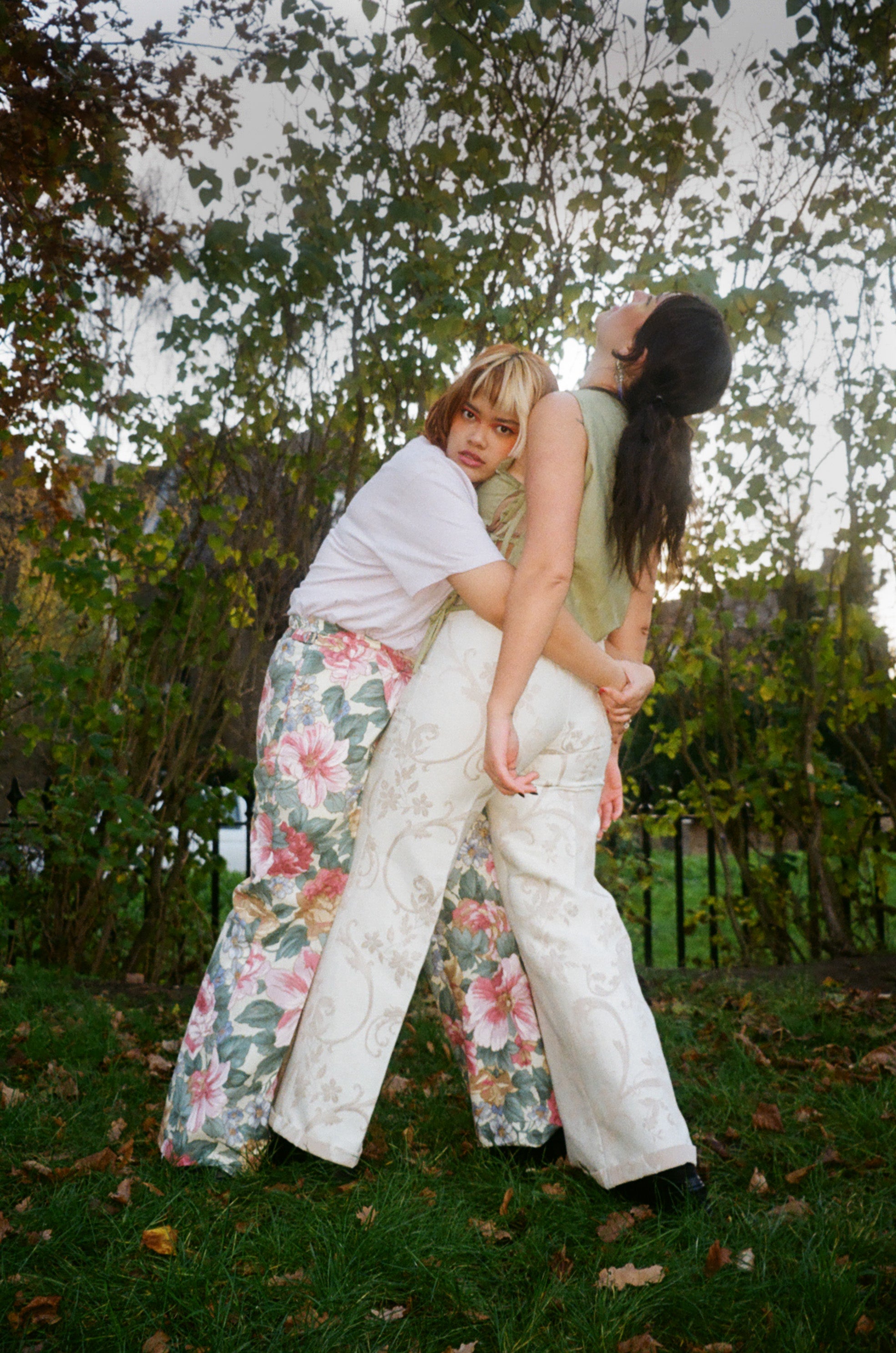 Two people embracing outdoors with a natural background