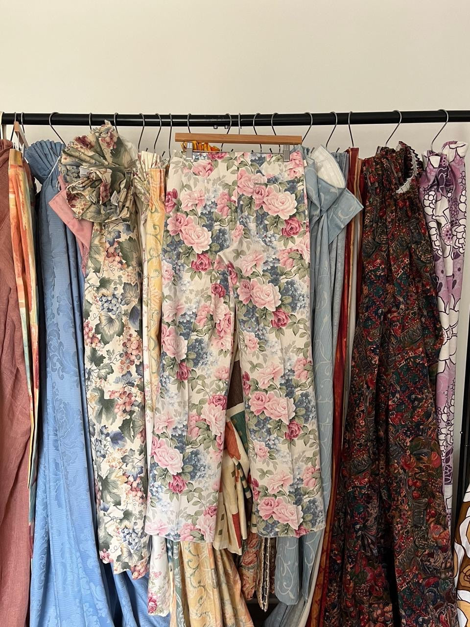 Vintage clothing on a rack with floral and patterned garments.