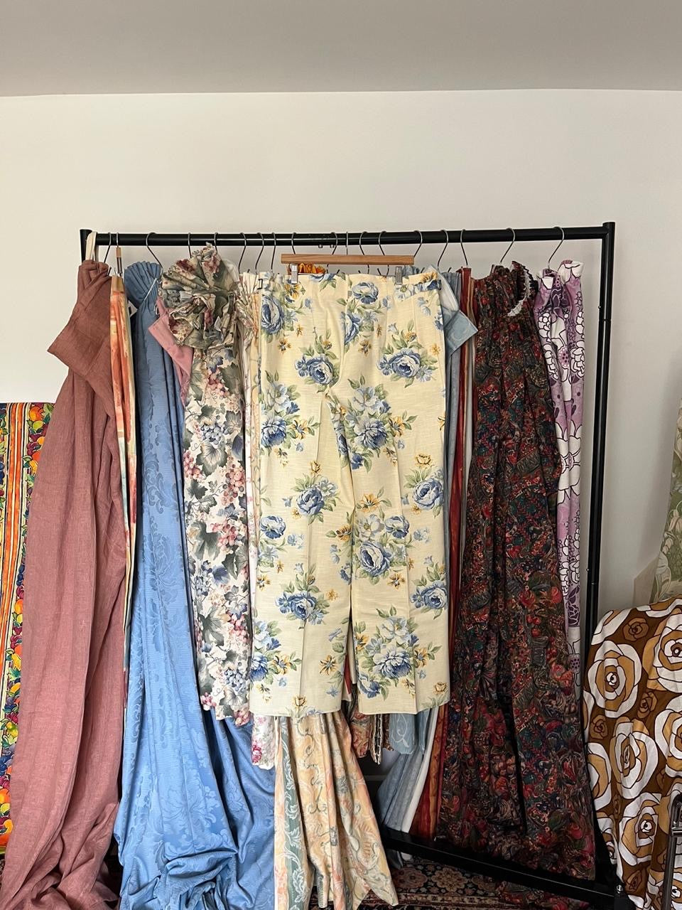 Vintage dresses hanging on a rack against a white wall