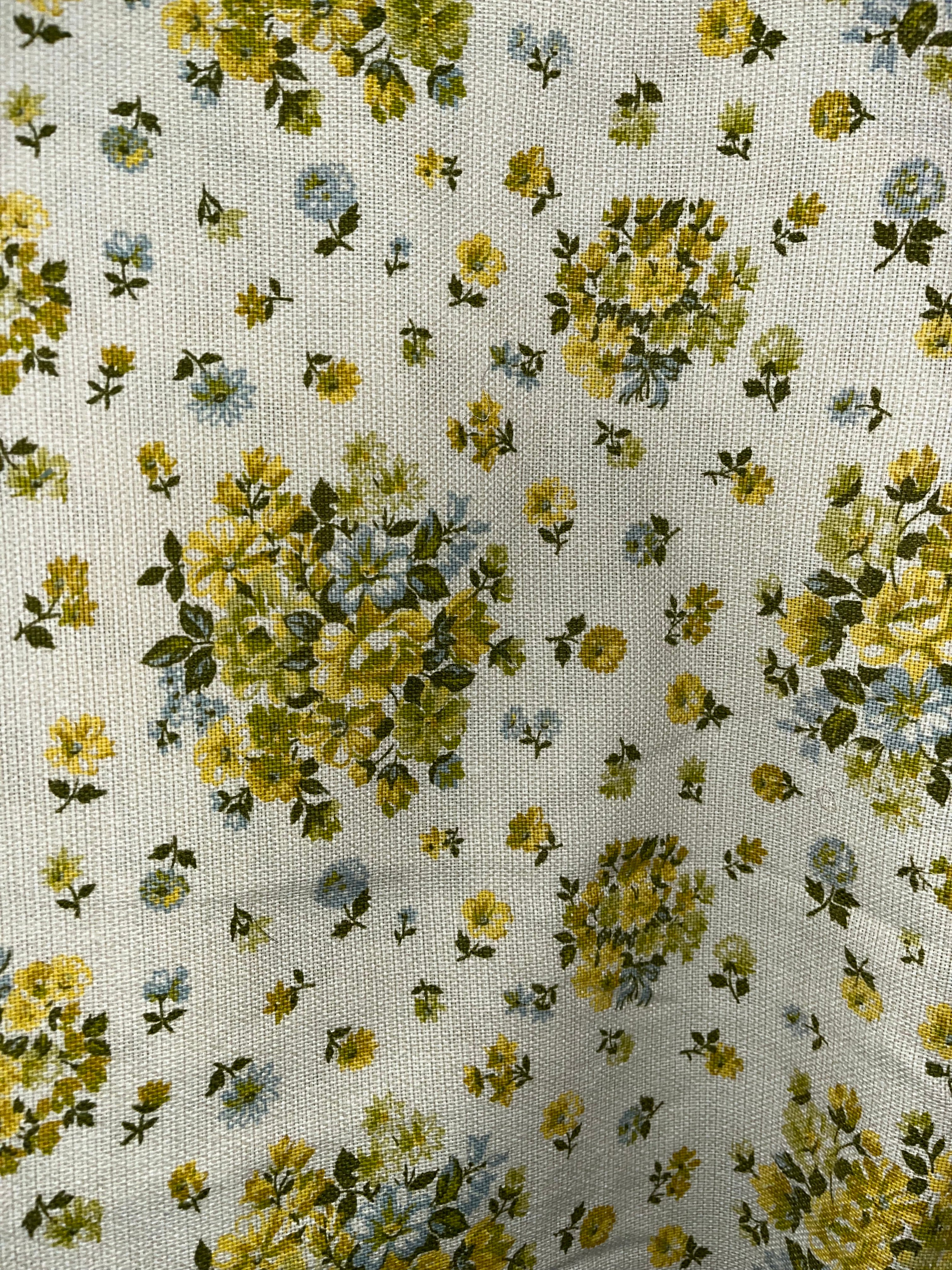 Floral patterned fabric with yellow and green flowers on a white background